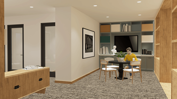 A person is sitting at a table in a room with a television and a bookshelf.